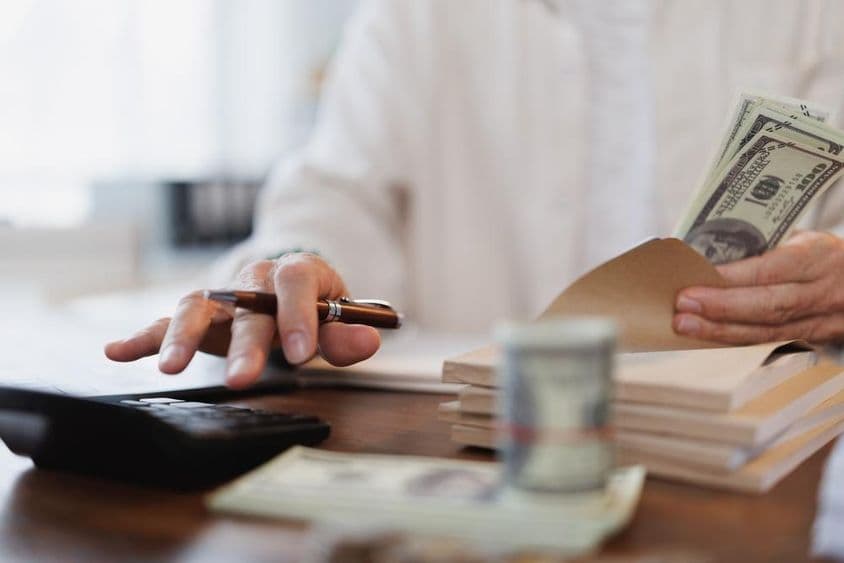 Vezető könyvelő amerikai százdolláros banokat számolja egy irodában.