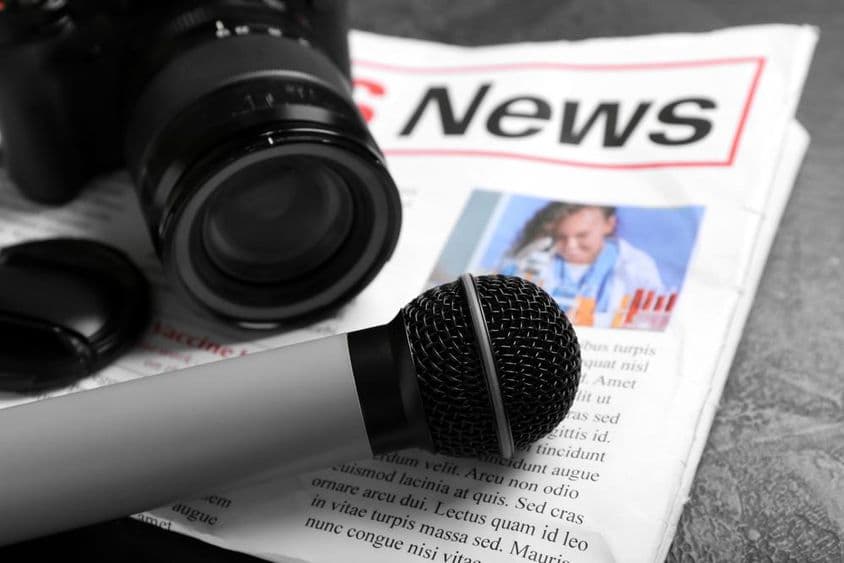 Újság mikrofonnal és fényképezőgéppel.