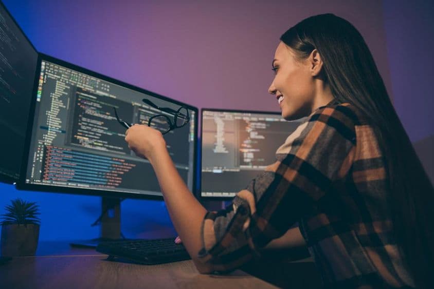 Egy fiatal lány kockás ingben, hibakeresési rendszerben dolgozik.