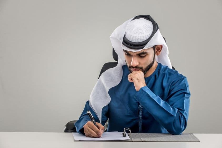 Arab férfi irodában szerződést ír.